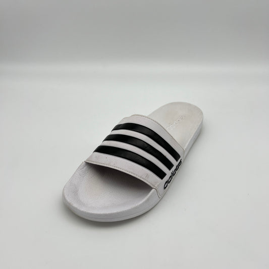 Gray slide sandal with black stripes on a light gray background