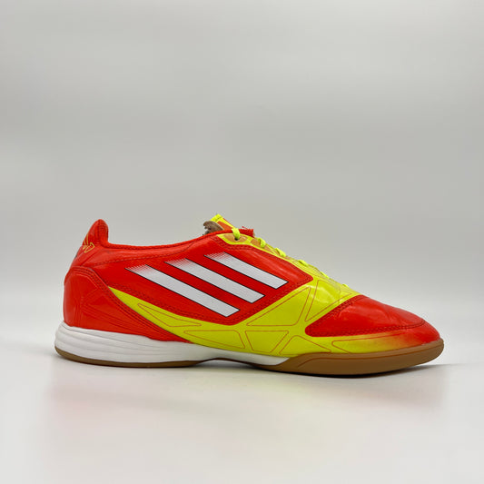 Red and yellow Adidas sports shoe on a gray background