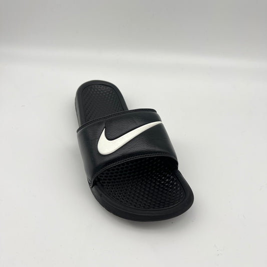 Black slide sandal with white Nike logo on a light gray background