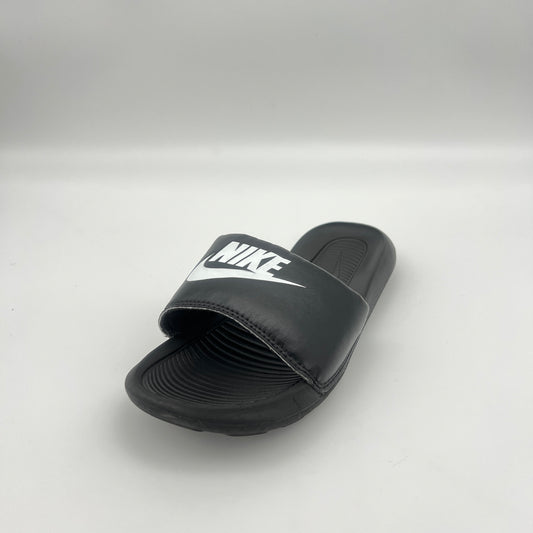 Black Nike slide sandal on a light gray background
