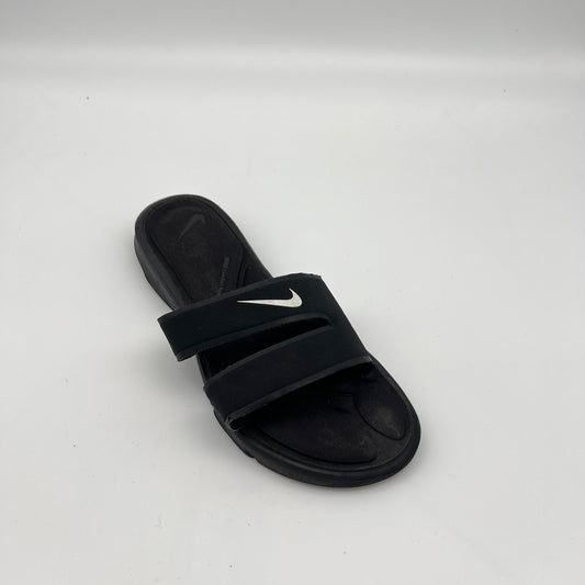 Black slide sandal with Nike logo on a white background