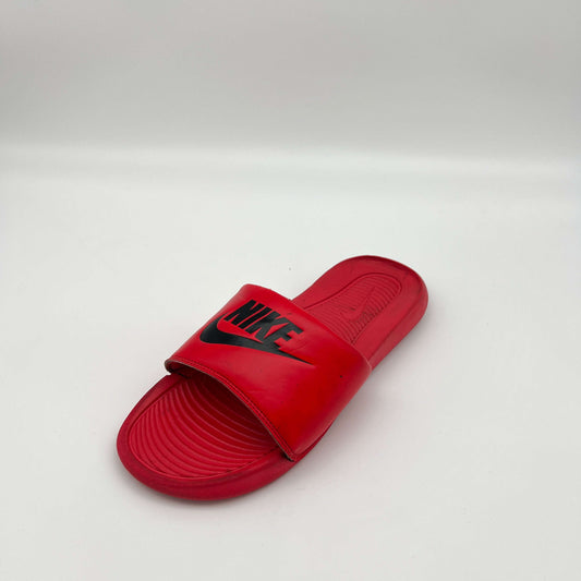 Close-up of the textured, contoured footbed and padded strap of the Nike Victori One slide in red