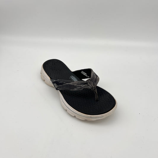 Black sandal with a white sole on a light gray background