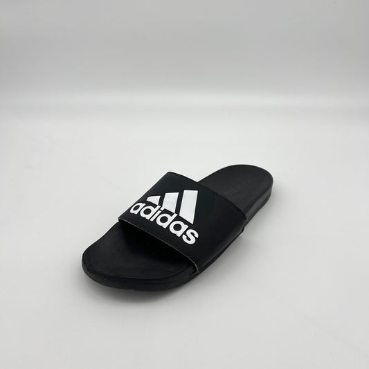 Close-up of the contoured Cloudfoam Plus footbed and synthetic bandage strap on an Adidas Adilette slide.