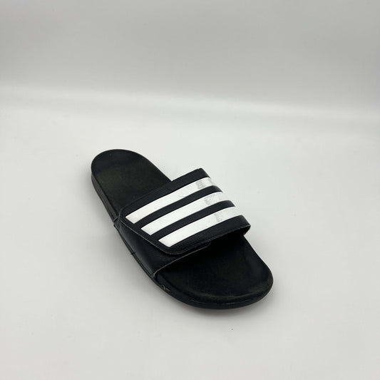 Black slide sandal with white stripes on a light gray background
