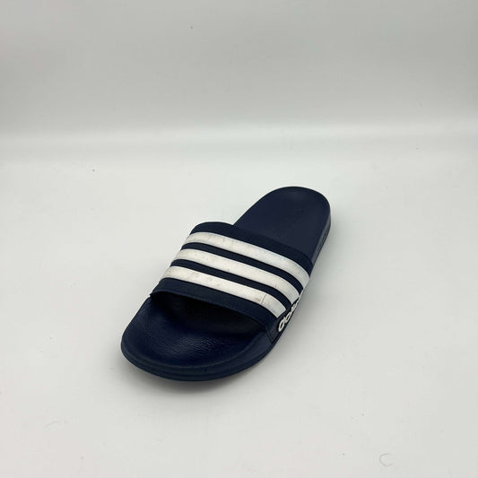Navy blue slide sandal with white stripes on a light gray background