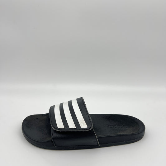 Black slide sandal with white stripes on a light gray background