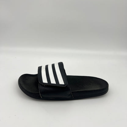 Side profile of black Adidas Adilette Comfort slides with an adjustable three-stripe strap and cushioned footbed.