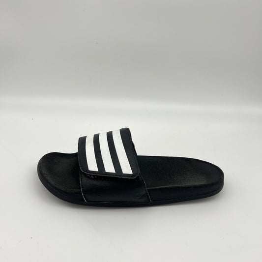 Side profile of black Adidas Adilette Comfort slides with an adjustable three-stripe strap and cushioned footbed.