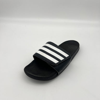 Black slide sandal with white stripes on a light gray background