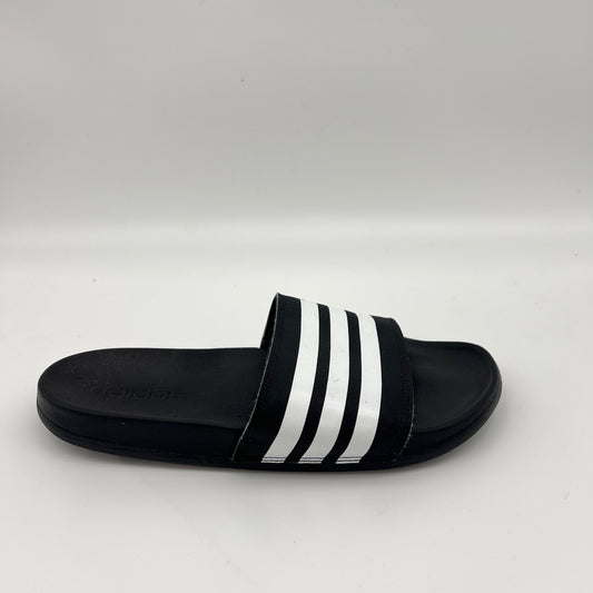 Black Adidas Adilette Comfort slide with three white stripes across the fixed synthetic strap.