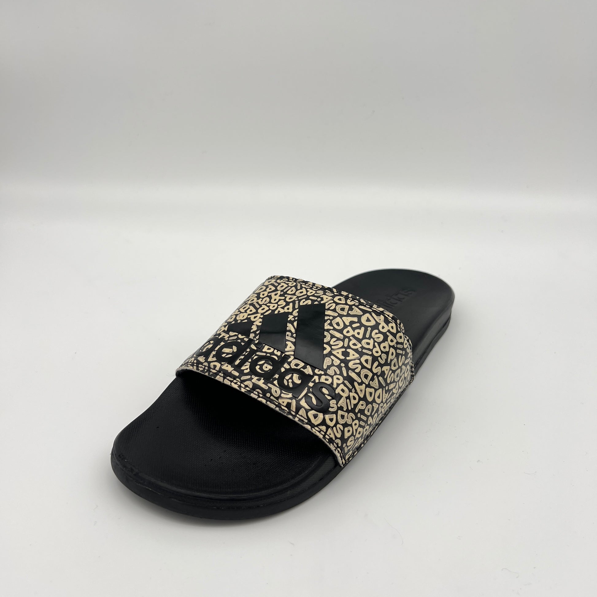Black slide sandal with leopard print strap on a white background
