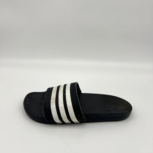 A single black Adidas Adilette Comfort slide sandal with three white stripes on a light grey background.