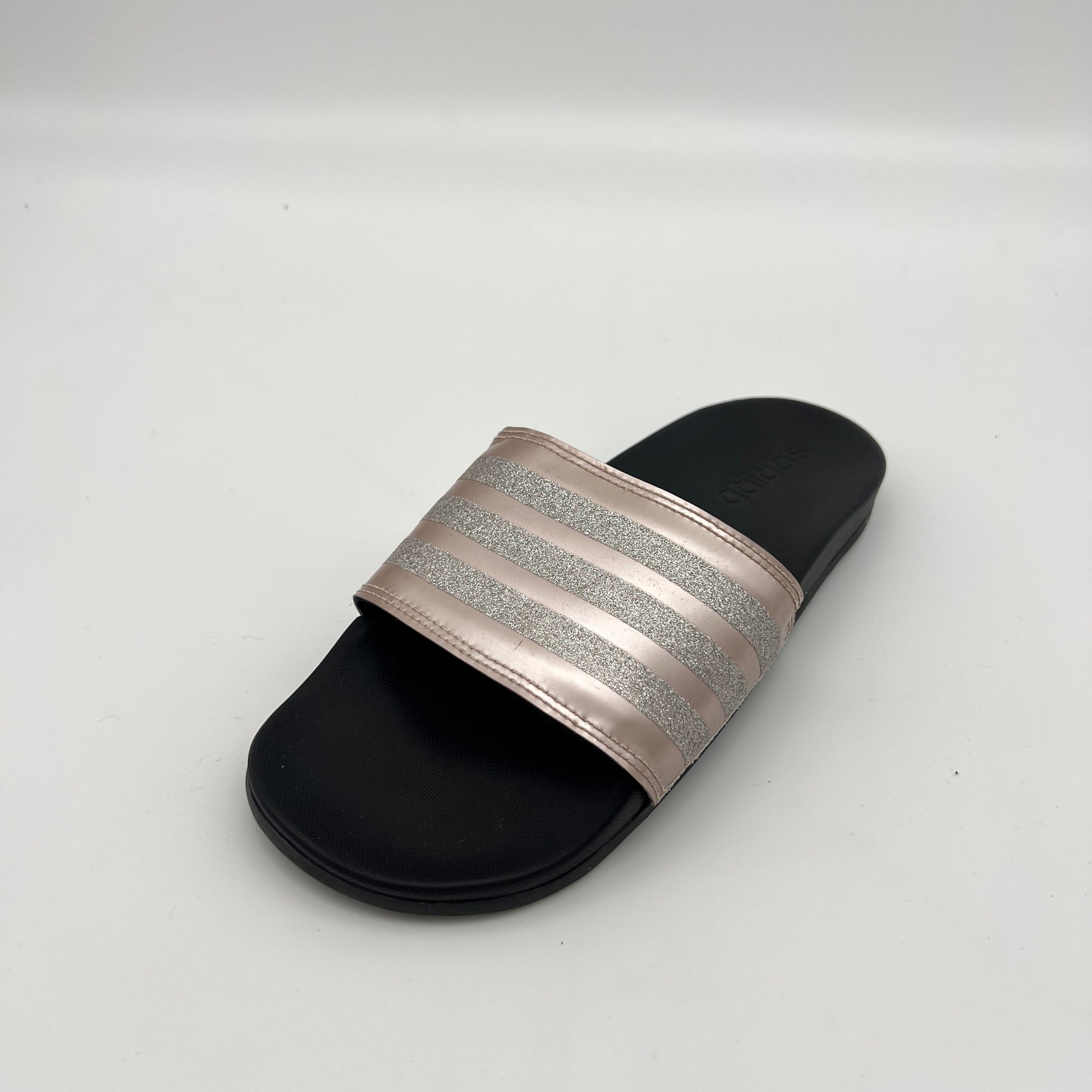 Black slide sandal with a glittery band on a white background