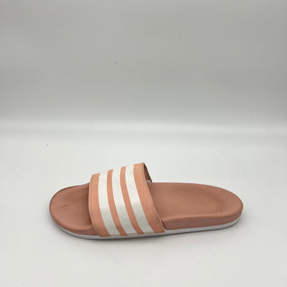 Pink Adidas Adilette Comfort slide sandal with white three-stripes and a contoured footbed.
