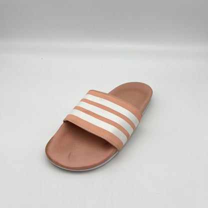 Brown slide sandal with white stripes on a light gray background