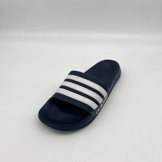 Black slide sandal with white stripes on a light gray background