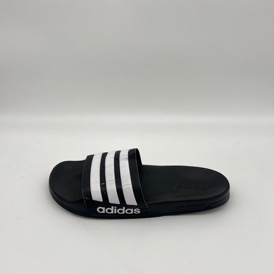 Side view of black Adidas Adilette Shower Slides with white stripes on the strap and a white Adidas logo on the side of the Cloudfoam midsole.