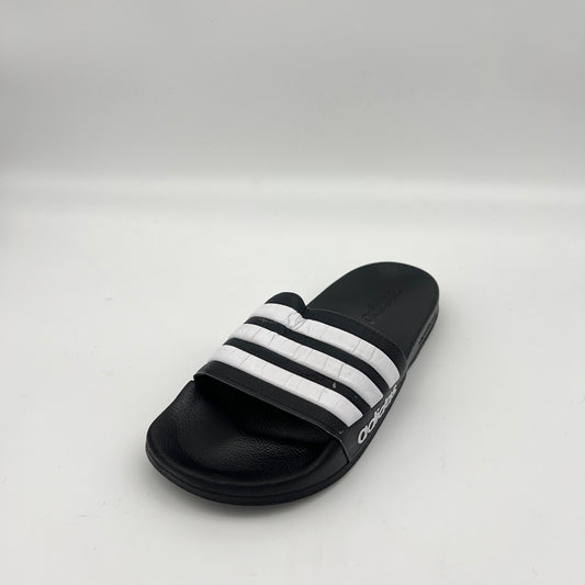Black slide sandal with white stripes on a light gray background