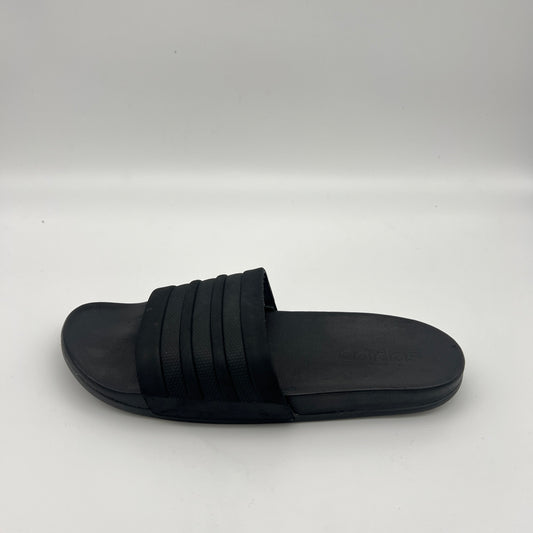 All-black Adidas Adilette Shower slides with tonal three-stripes and a contoured footbed.