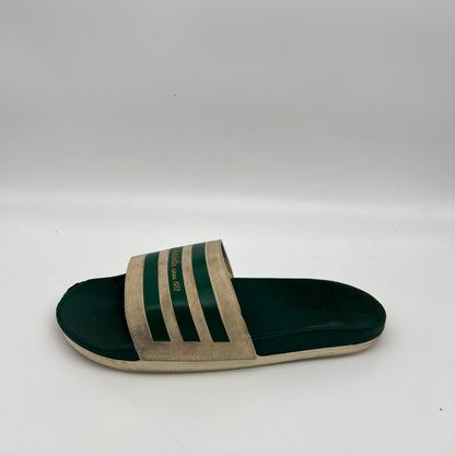 Adidas Adilette Since 1972 slides in off-white and forest green.