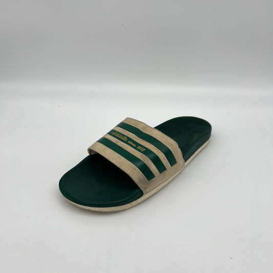 Green and beige slide sandal with three stripes on a white background