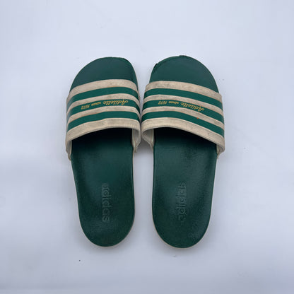 Men's vintage-style Adidas slides; comfortable forest green and cream Adilette sandals with heritage branding and contoured sole.