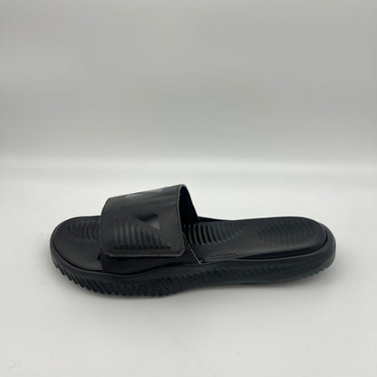 Side view of all-black Adidas Alphabounce Slides featuring a textured footbed and an adjustable velcro strap with the embossed 3-stripe logo.
