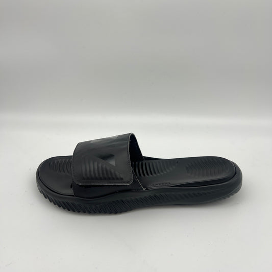 Side view of all-black Adidas Alphabounce Slides featuring a textured footbed and an adjustable velcro strap with the embossed 3-stripe logo.
