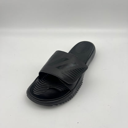 Side view of all-black Adidas Alphabounce Slides featuring a textured footbed and an adjustable velcro strap with the embossed 3-stripe logo.