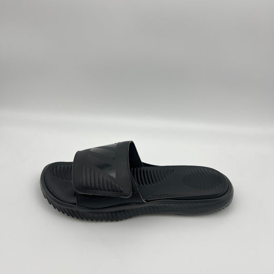 A side profile of an all-black Adidas Alphabounce slide featuring an adjustable strap with debossed branding and a thick, contoured Bounce cushioned sole.