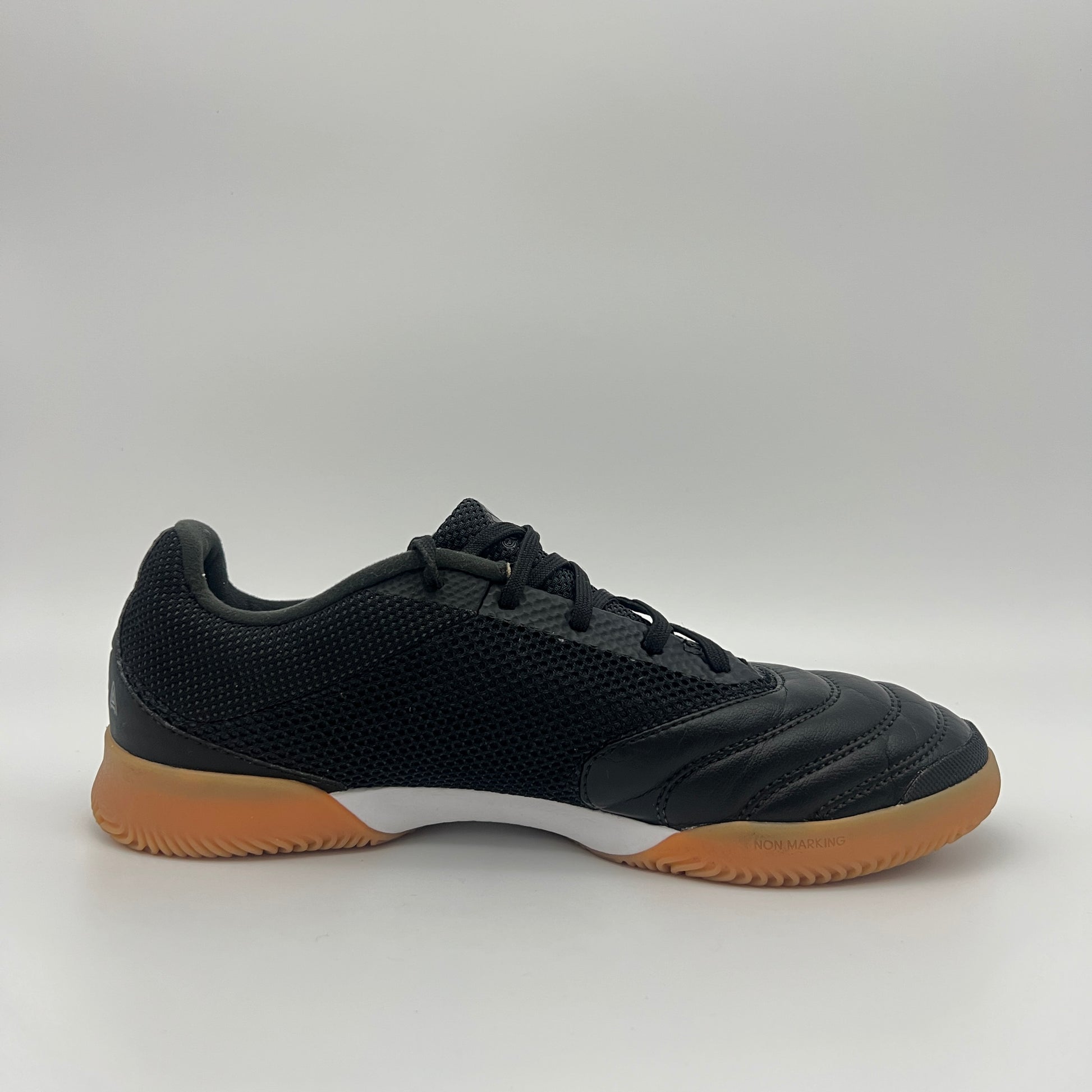 Side view of a black Adidas Copa 19.3 indoor soccer shoe with tonal three stripes, a white midsole, and a tan gum sole on a gray background.