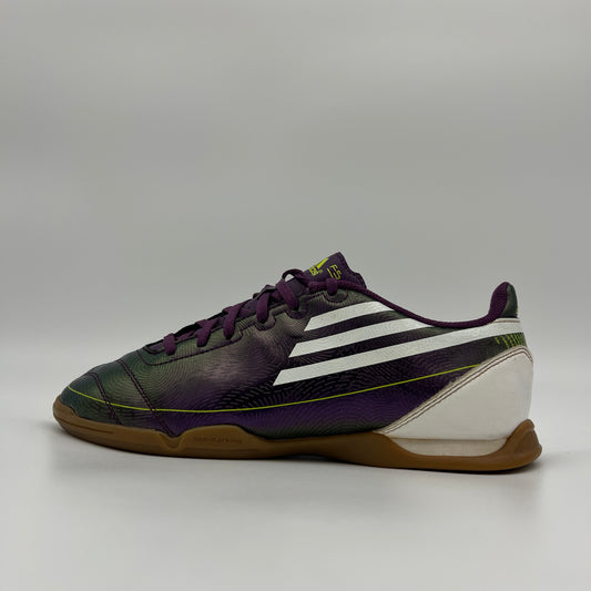 Side profile of a purple Adidas F10 indoor soccer shoe with white stripes and a gum rubber sole