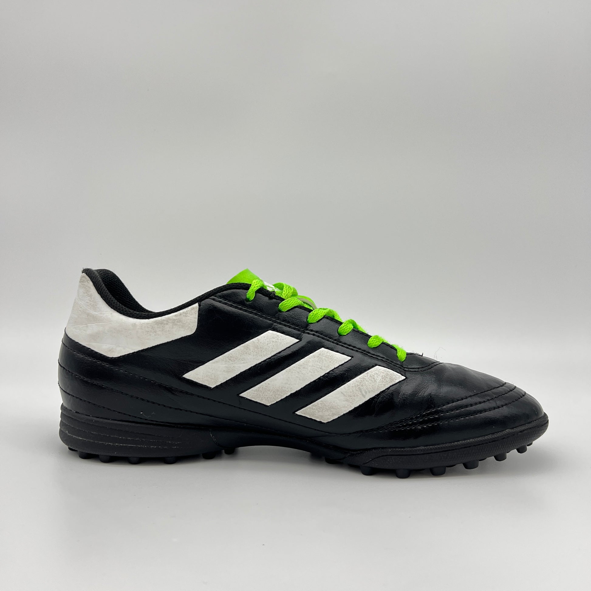 Side view of black Adidas Goletto VI TF soccer shoe with white stripes and green laces