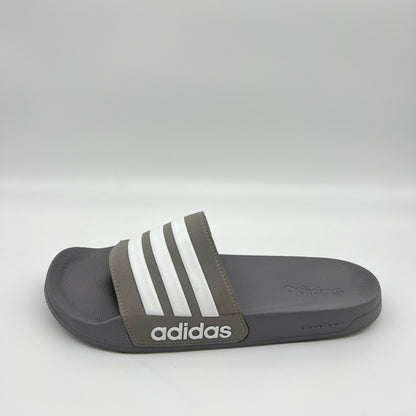 Gray Adidas slide sandal with three white stripes on a light gray background