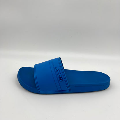A side view of a solid blue Aldo Dinmore slide sandal featuring a thick rubber strap with a debossed Aldo logo on a contoured footbed.