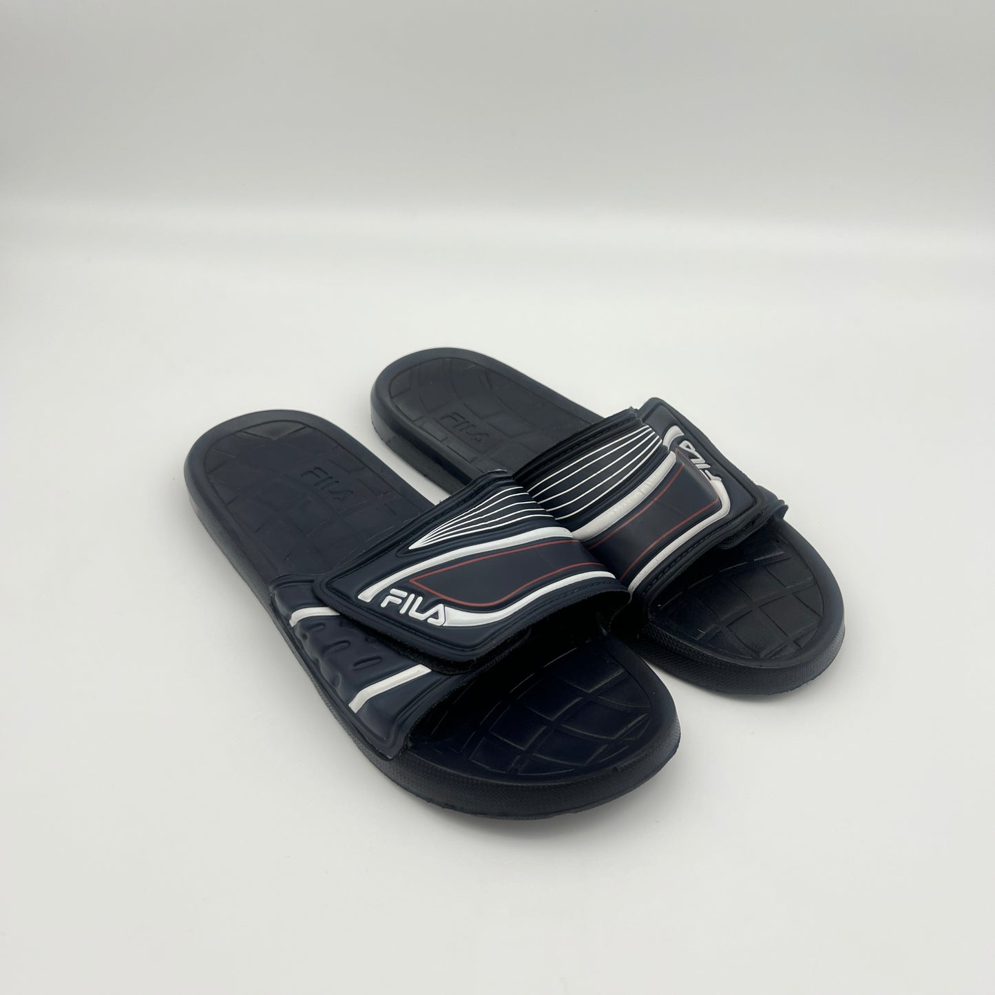 Pair of black slides with white accents on a light gray background