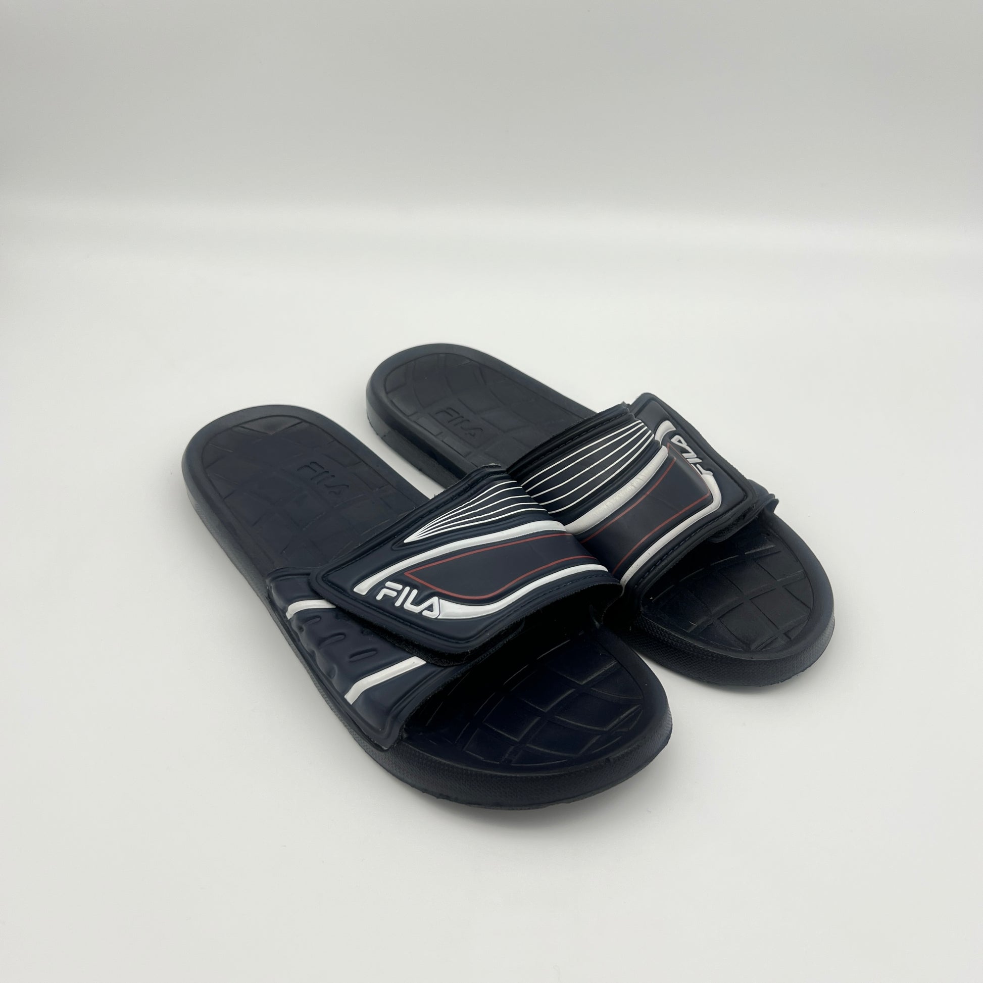 Pair of black slides with white accents on a light gray background