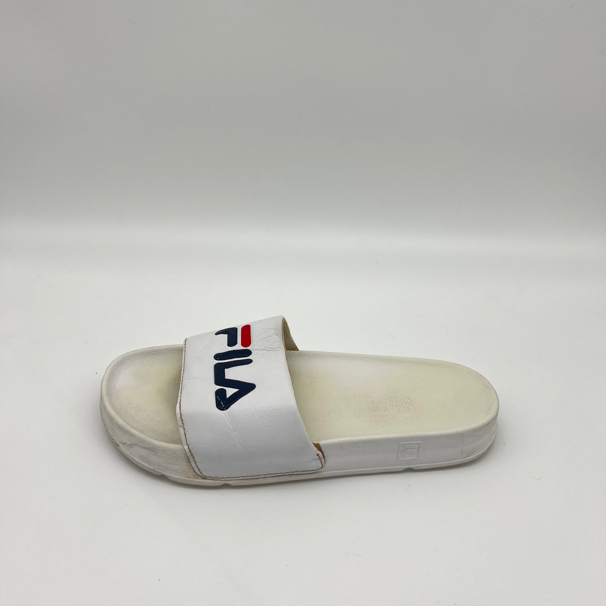 A side view of a white Fila Morro Bay 2.0 slide featuring a navy and red Fila logo on the strap and a thick, contoured sole