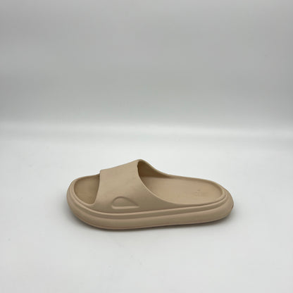 Side profile of a single tan-colored, minimalist EVA foam slide sandal for kids on a clean white background.