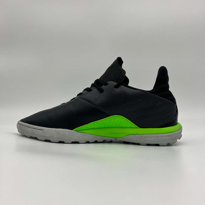 Side view of a black Kipsta Viralto I turf soccer shoe with a vibrant lime green midsole and grey rubber studded outsole against a plain grey background.