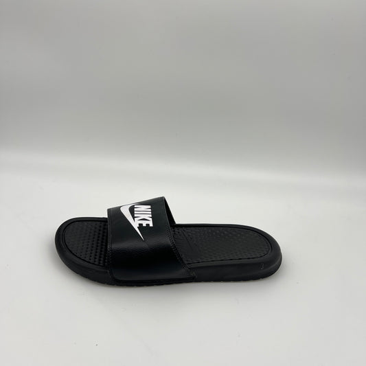 Side view of a single black Nike Benassi JDI slide sandal featuring a bold white Swoosh logo on the strap and a textured footbed on a plain white background.