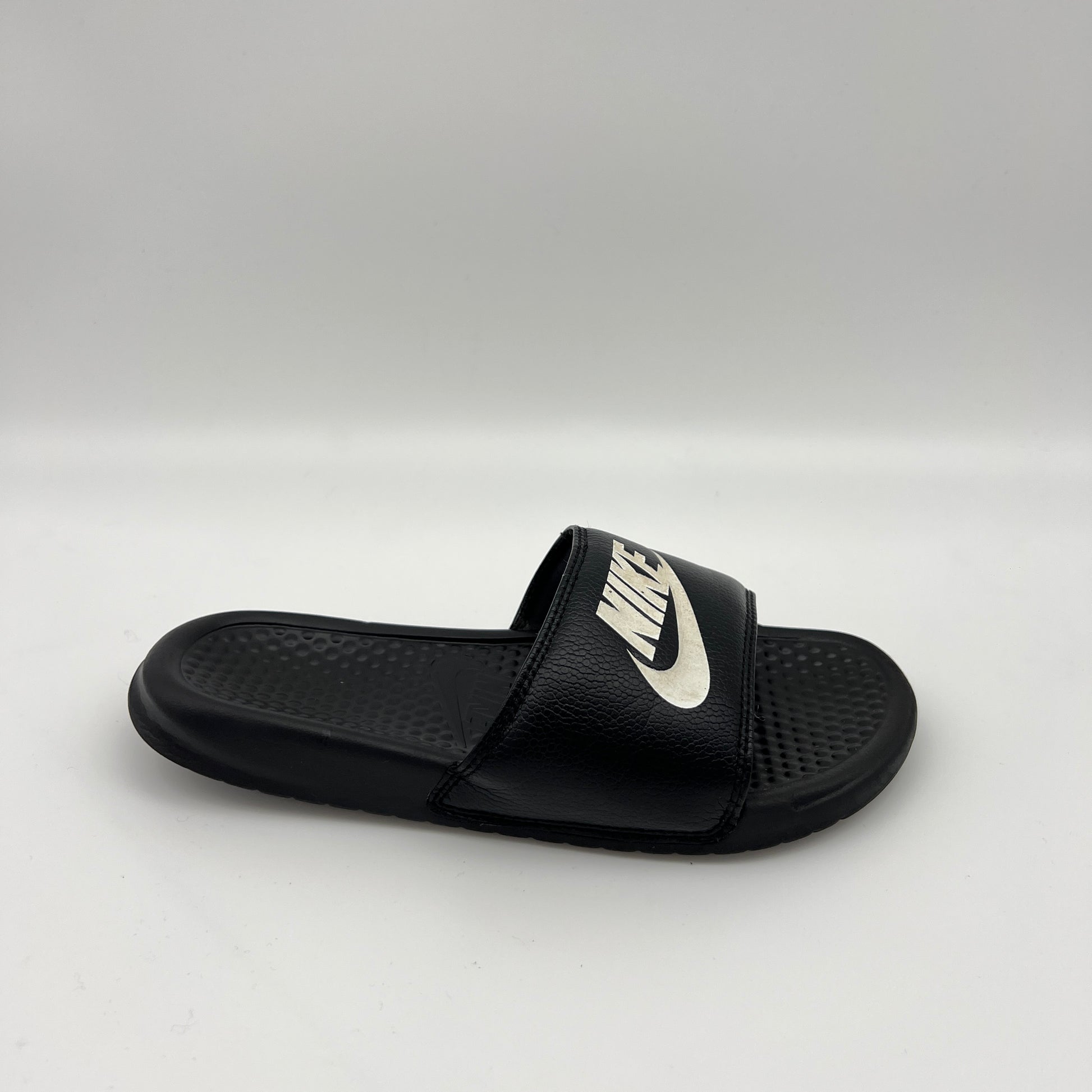Black slide sandal with Nike logo on a white background