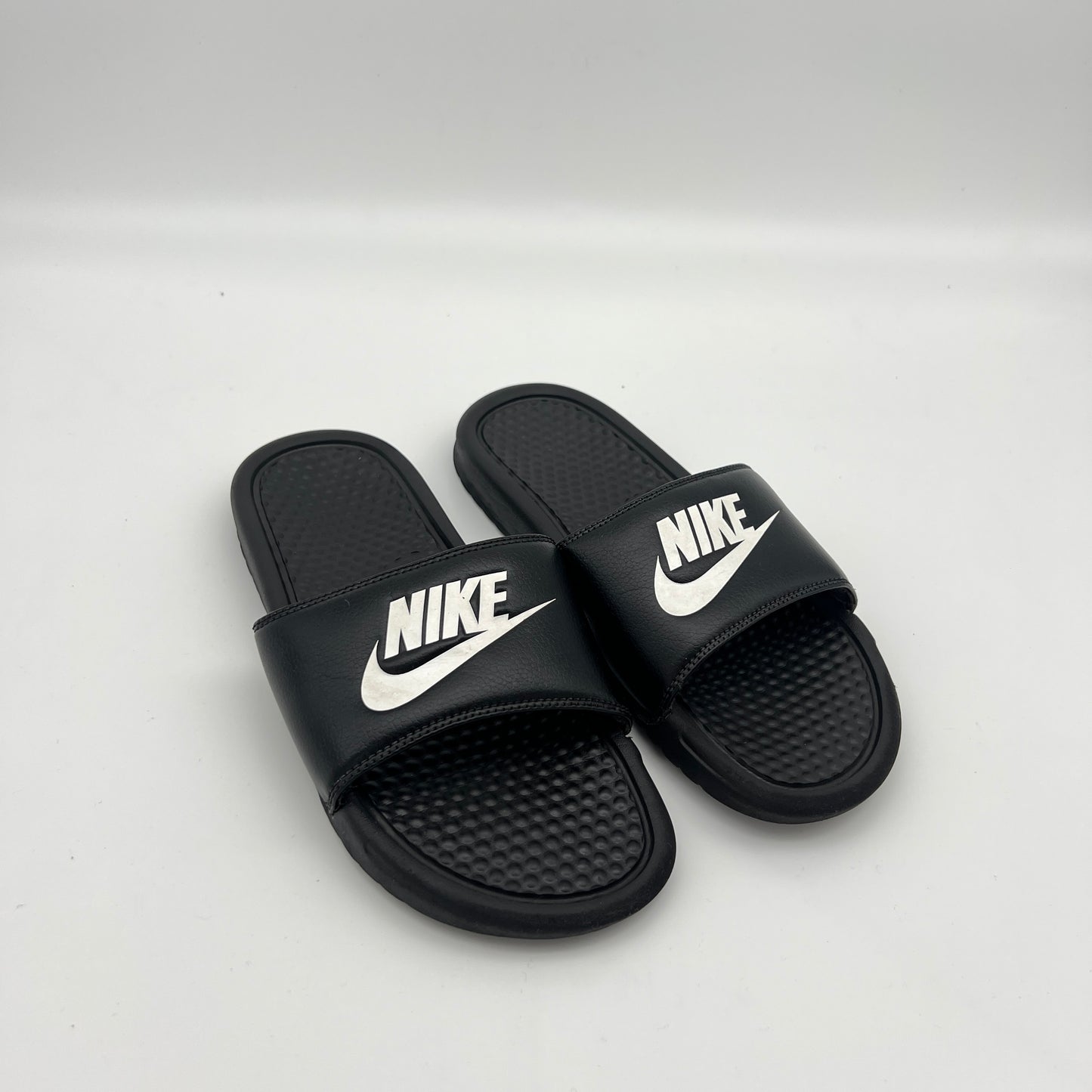 Lightweight black Nike sandals with a massaging footbed and durable Phylon outsole.
