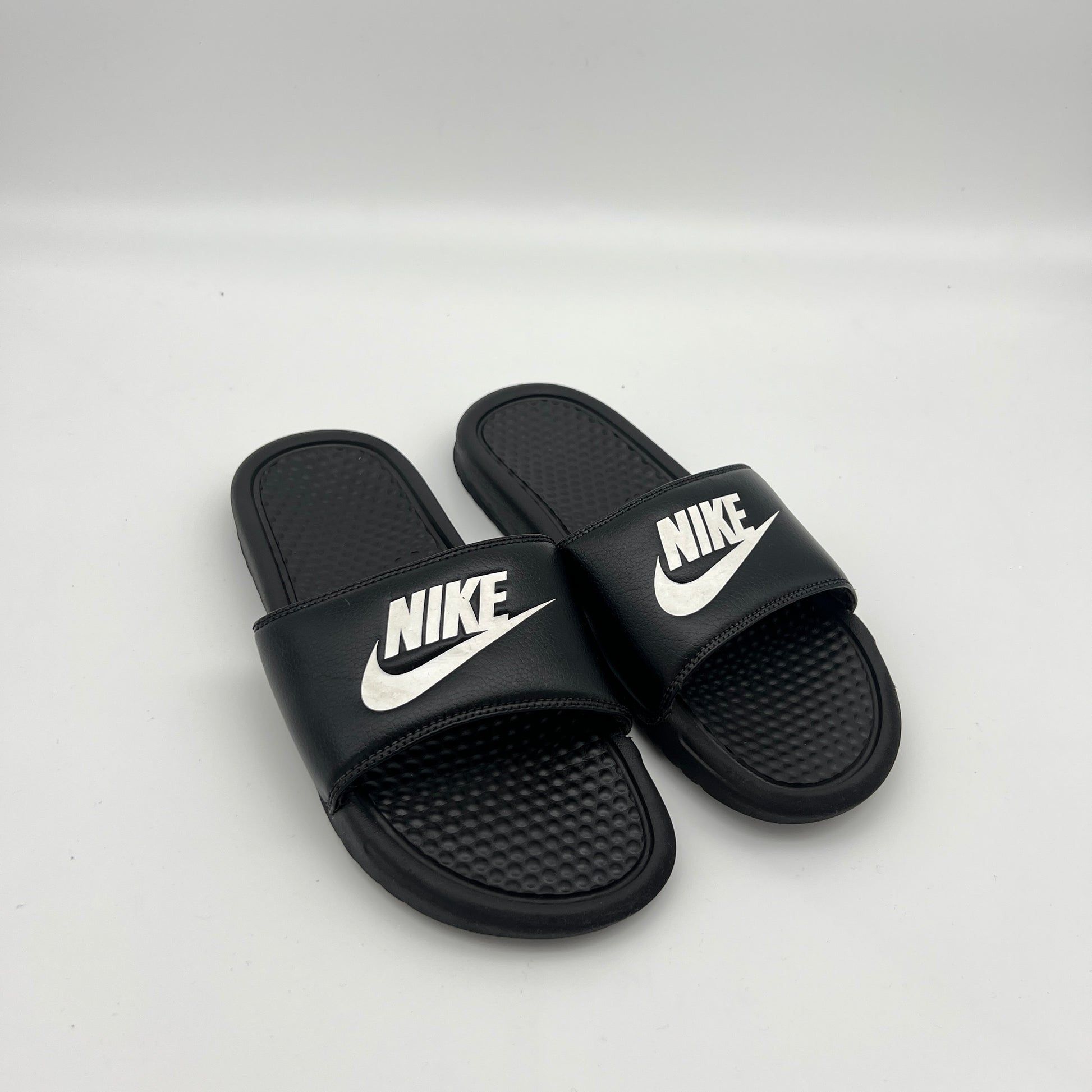 Lightweight black Nike sandals with a massaging footbed and durable Phylon outsole.
