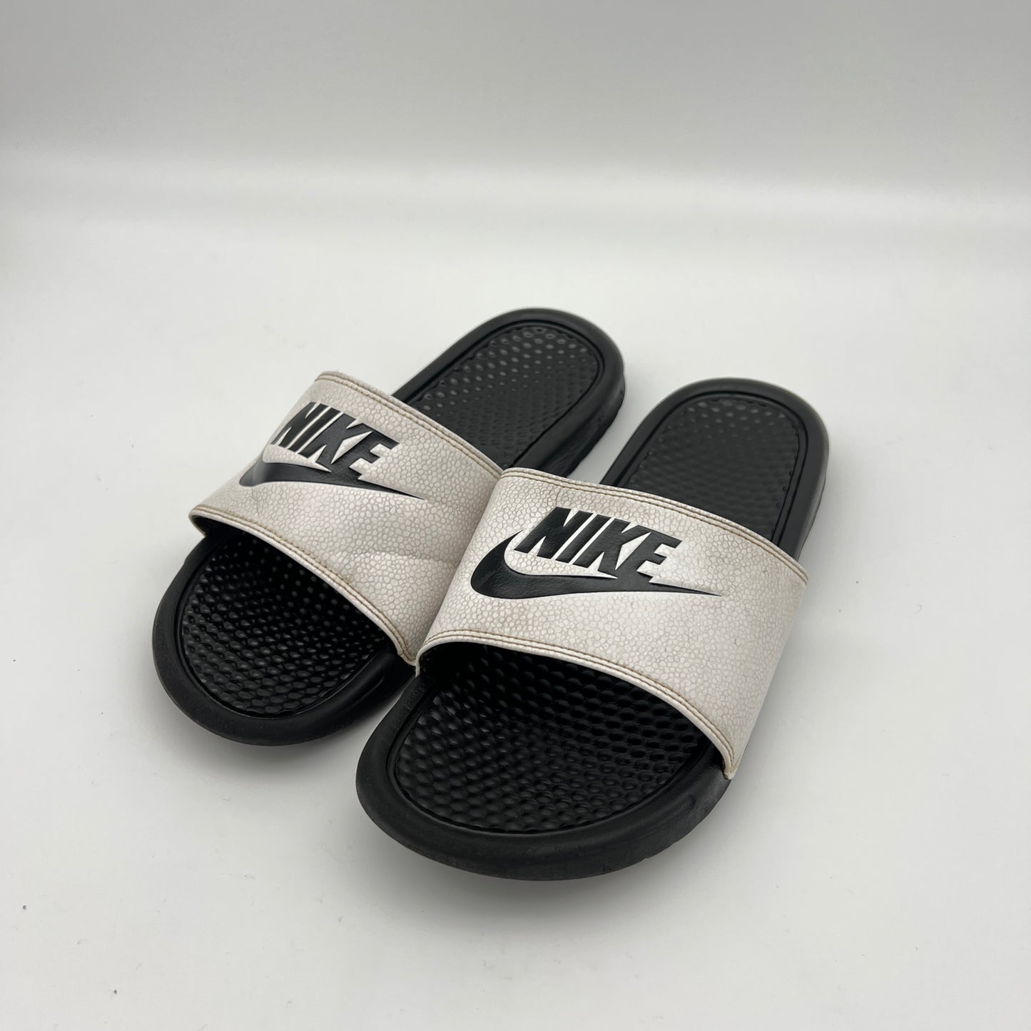 Pair of Nike slides on a light gray background
