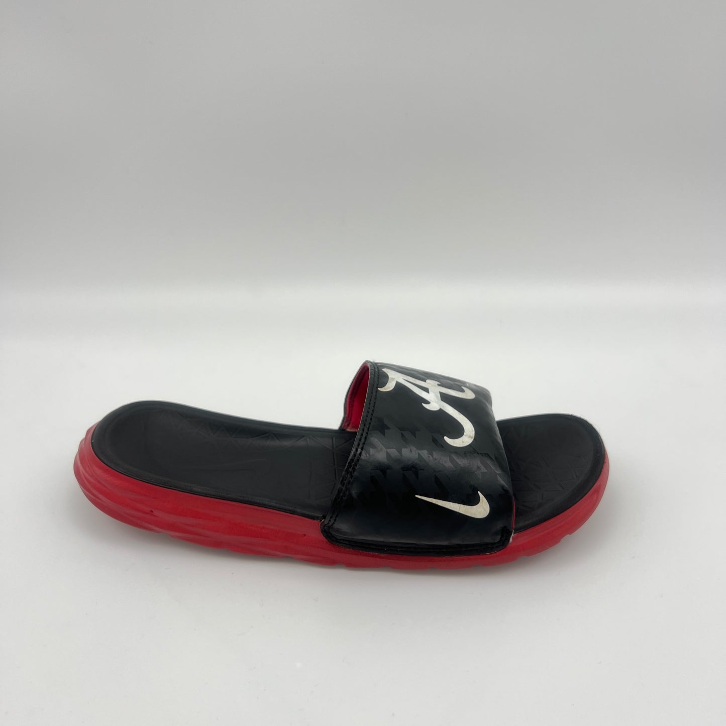 Black and red slide sandal with a logo on a white background