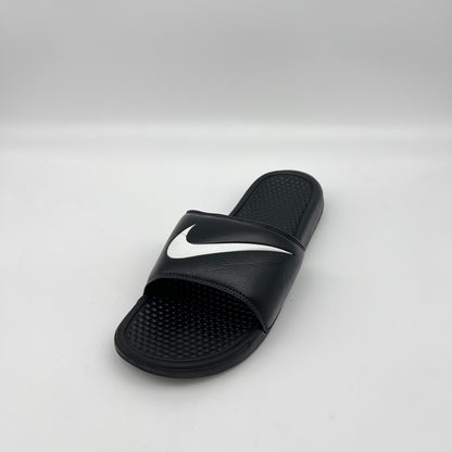 Black slide sandal with a white logo on a light gray background