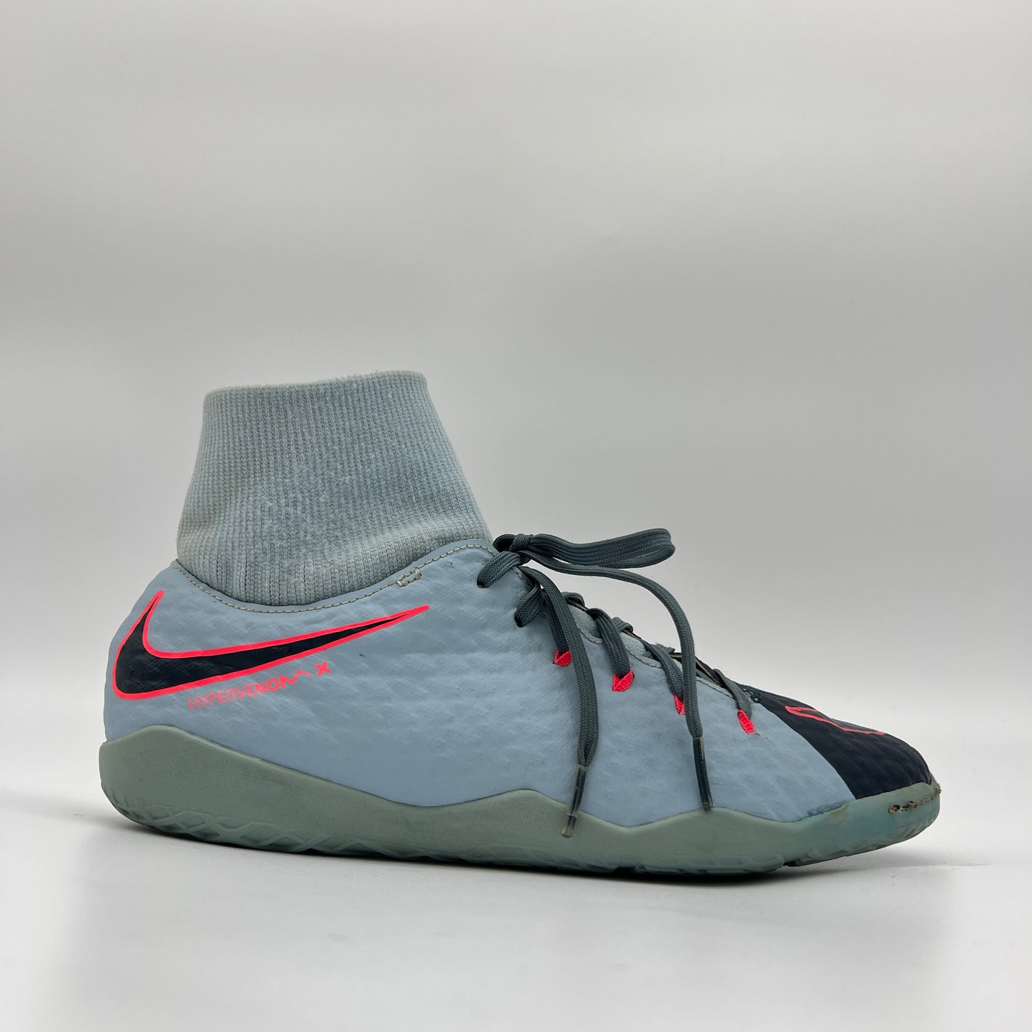 Side view of a grey and red Nike HypervenomX Phelon III Dynamic Fit indoor soccer shoe with a light grey sock-like collar and black Nike swoosh.