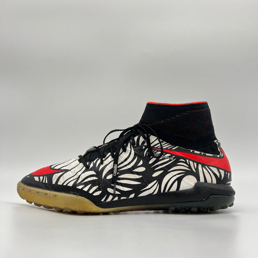 Side profile of a Nike HypervenomX Proximo Neymar Jr. TF turf shoe with a black and white 'Ousadia Alegria' graphic, red Nike swoosh, and black sock collar.
